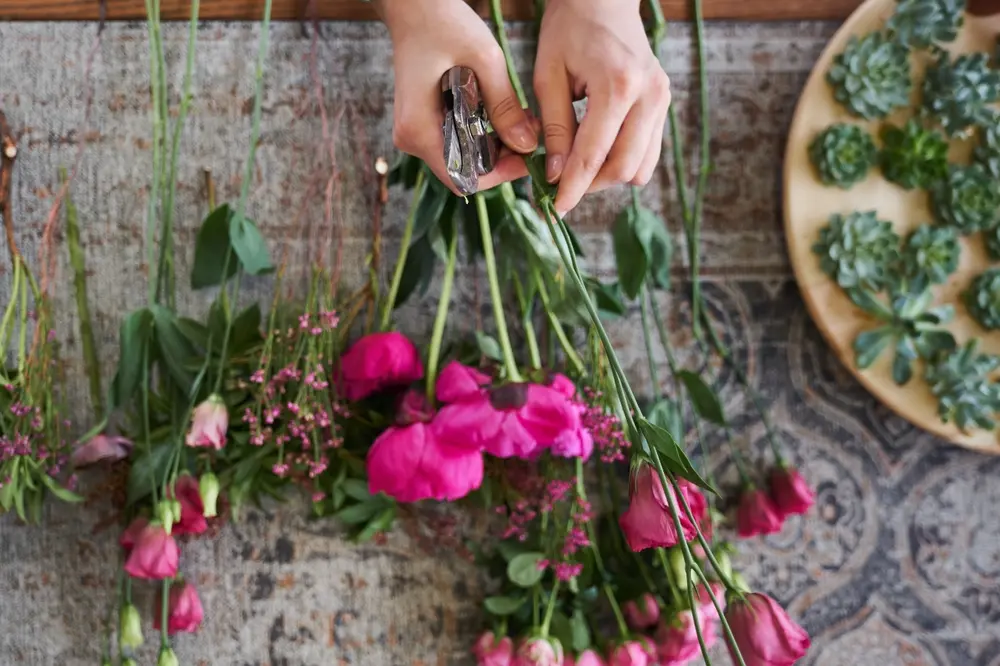 Florist arranging fuchsia pink flowers for handcrafted floral designs in Brentwood, PA