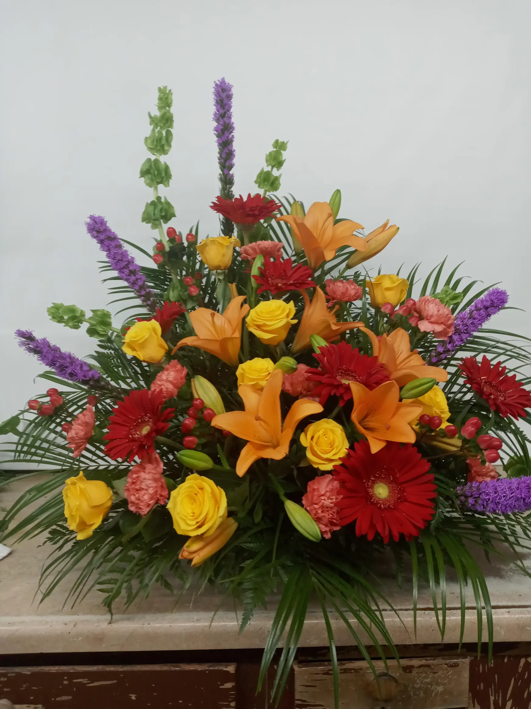 Florist holding a handcrafted flower arrangement at Klein’s Flower Shop